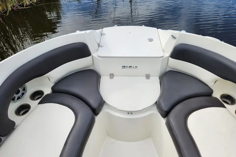 Slide: The Image of 2017 Stingray 214 LR boat interior with cushioned seating and cup holders. - 6