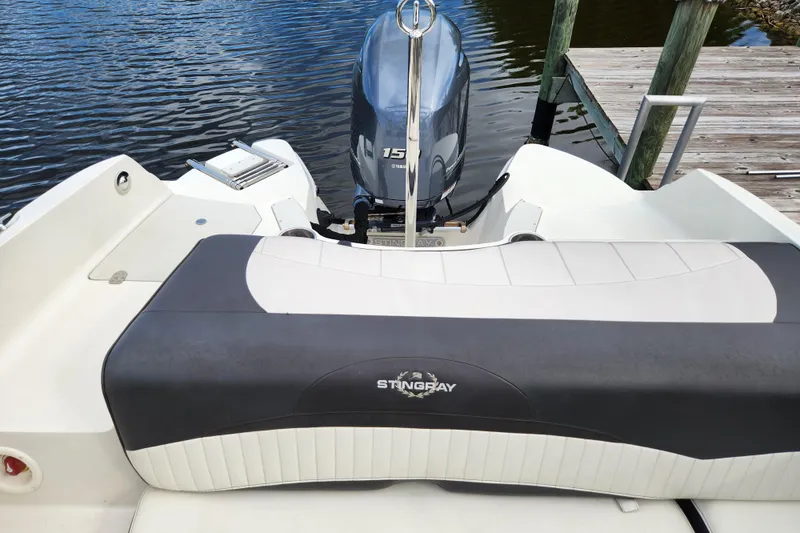 Slide: The Image of 2017 Stingray 214 LR boat with outboard motor docked by wooden pier. - 9