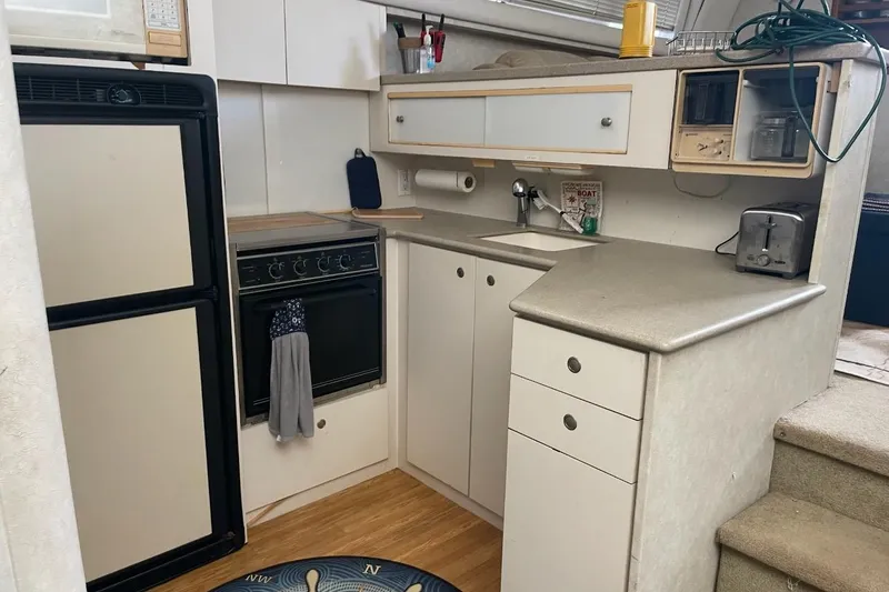 Slide: The Image of 1997 Silverton 402 Motor Yacht kitchen with appliances and storage cabinets. - 15