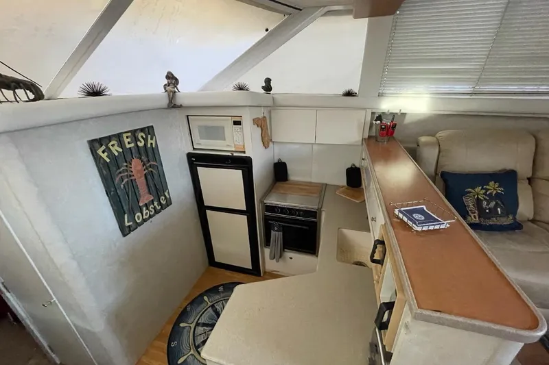 Slide: The Image of Interior of 1997 Silverton 402 Motor Yacht with kitchenette and cozy seating area. - 16