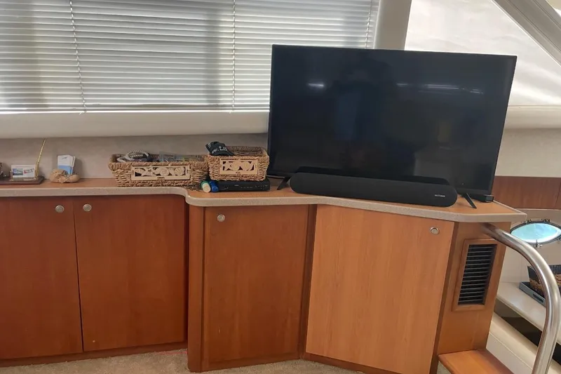 Slide: The Image of 1997 Silverton 402 Motor Yacht interior with TV, soundbar, and wooden cabinetry. - 19
