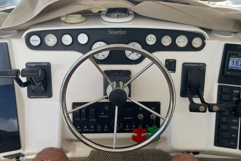Slide: The Image of 1997 Silverton 402 Motor Yacht helm with steering wheel and control panel. - 21