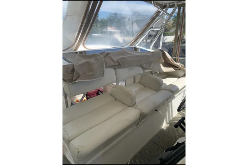 Slide: The Image of 1997 Silverton 402 Motor Yacht interior with white seating and covered helm area. - 22