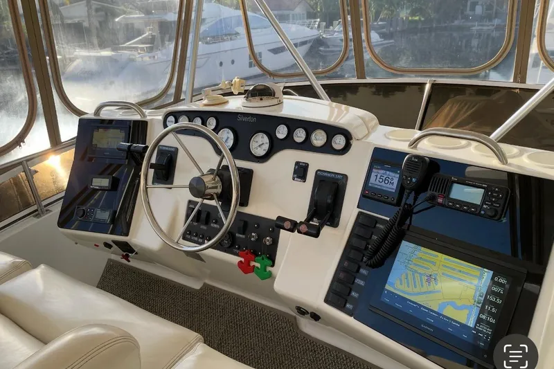 Slide: The Image of 1997 Silverton 402 Motor Yacht helm with navigation instruments and steering wheel. - 23
