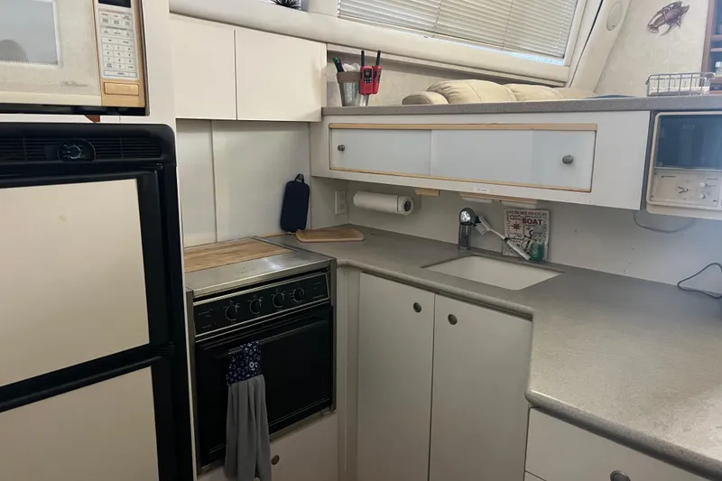 Slide: The Image of Compact kitchen in a 1997 Silverton 402 Motor Yacht with stove, microwave, and sink. - 27