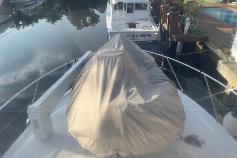 Slide: The Image of 1997 Silverton 402 Motor Yacht docked, covered, with calm water reflection. - 5