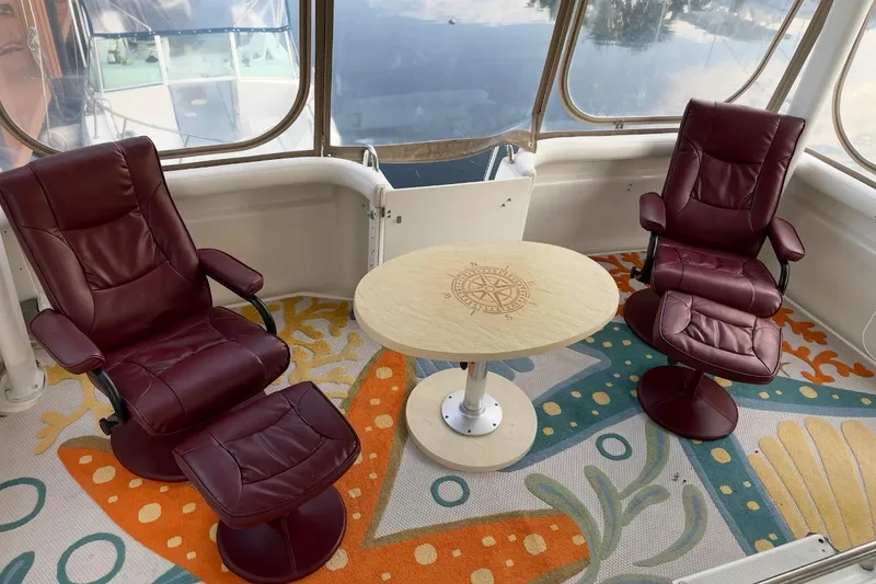 Slide: The Image of Luxurious 1997 Silverton 402 Motor Yacht interior with burgundy chairs and nautical-themed decor. - 6