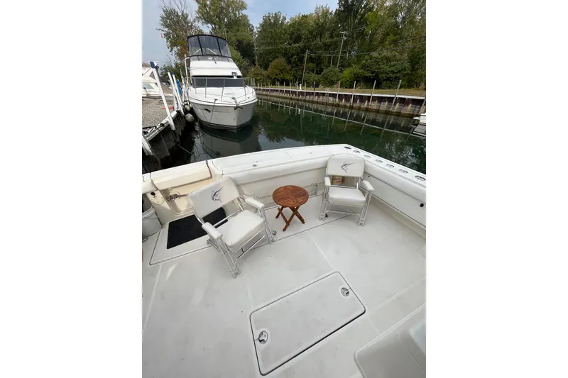 Slide: The Image of 1992 Tiara Yachts 4300 Open deck with chairs and table, docked near another boat. - 5