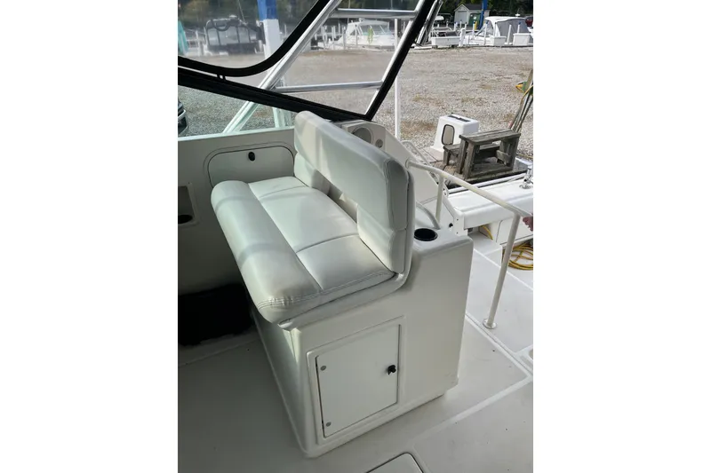 Slide: The Image of 1992 Tiara Yachts 4300 Open interior with white cushioned seating and storage. - 6