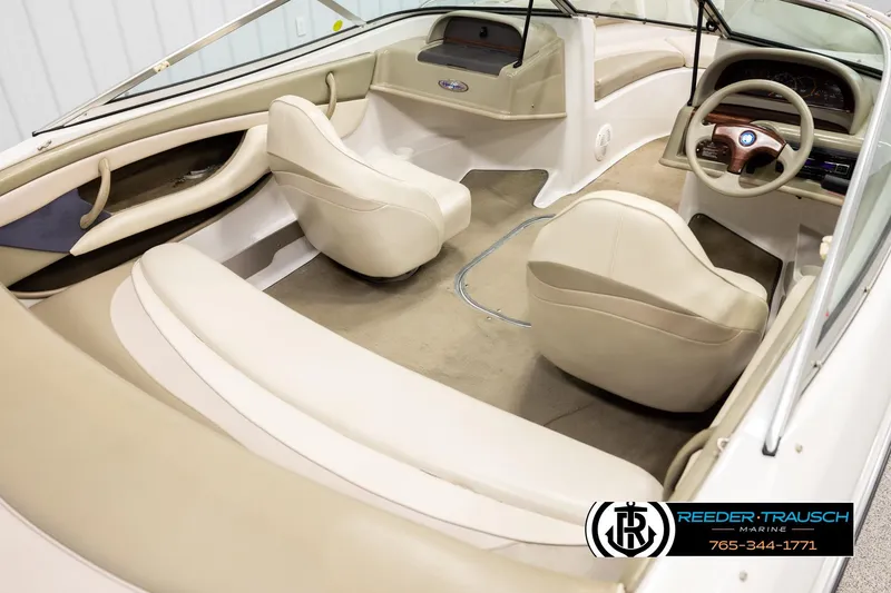 Slide: The Image of 1999 Four Winns 180 Horizon boat interior with beige seating and steering wheel. - 11