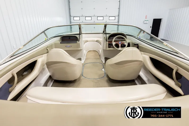 Slide: The Image of 1999 Four Winns 180 Horizon boat interior with beige seating and steering wheel. - 12