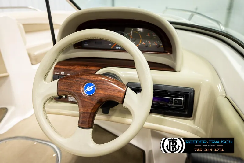 Slide: The Image of 1999 Four Winns 180 Horizon boat dashboard with wood-accented steering wheel and instrument panel. - 21