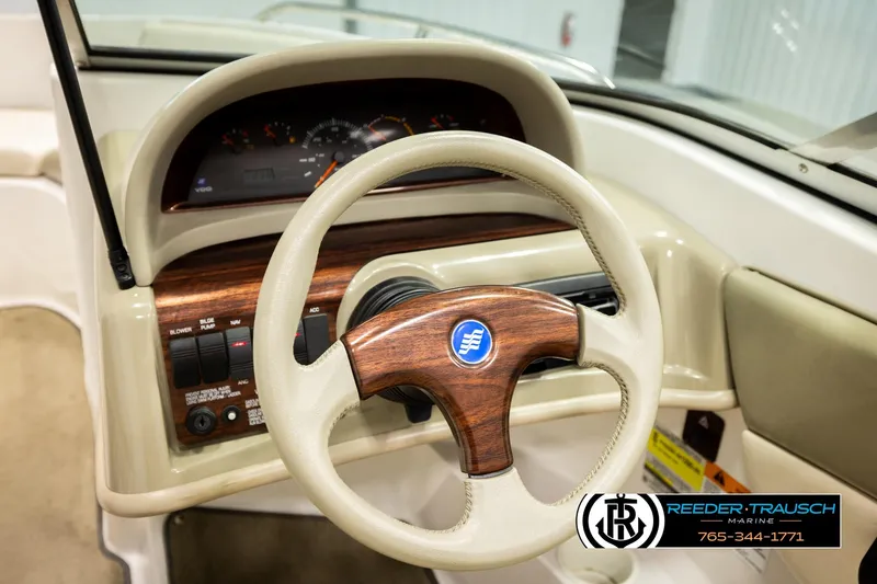 Slide: The Image of 1999 Four Winns 180 Horizon boat dashboard with wood-accented steering wheel and controls. - 22