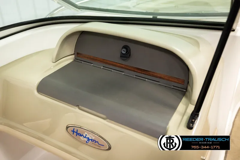 Slide: The Image of 1999 Four Winns 180 Horizon boat dashboard with storage compartment and Horizon logo. - 31