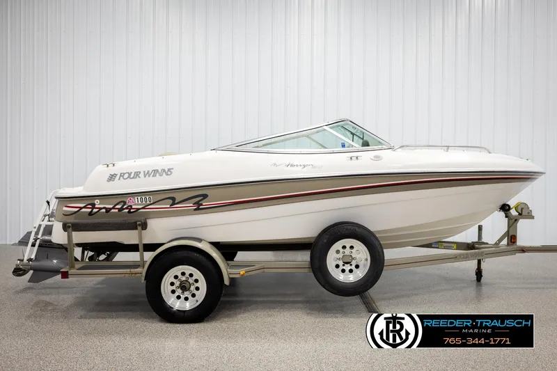 Slide: The Image of 1999 Four Winns 180 Horizon boat on trailer, displayed indoors at Reeder-Trausch Marine. - 4
