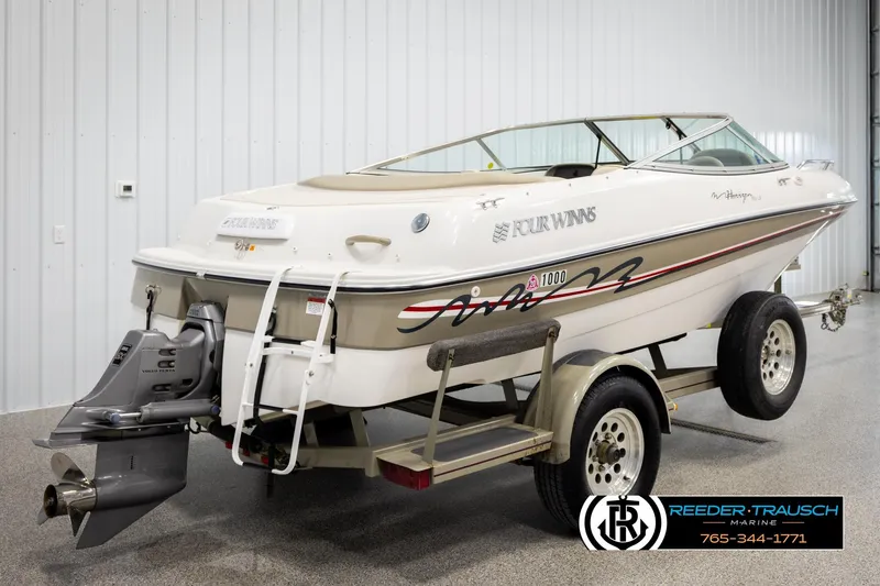 Slide: The Image of 1999 Four Winns 180 Horizon boat on trailer in showroom, rear view. - 5