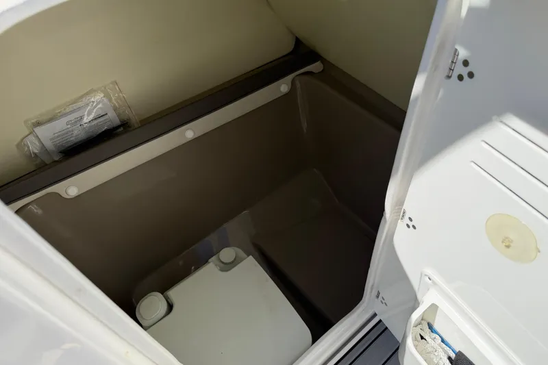 Slide: The Image of Storage compartment inside 2014 Yamaha Boats 242 Limited S, featuring organized space and accessories. - 23