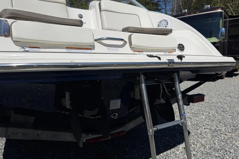 Slide: The Image of 2014 Yamaha Boats 242 Limited S with swim platform and ladder, parked on gravel. - 26