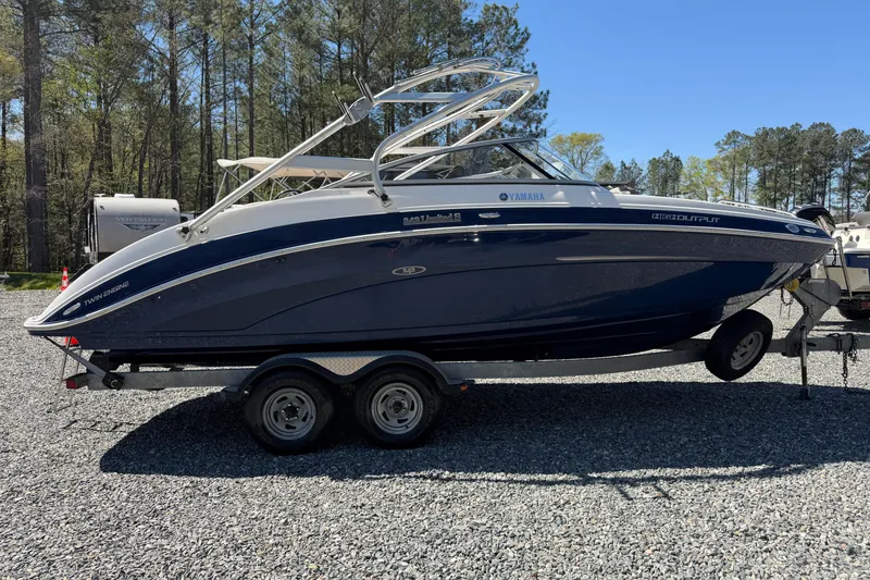 Slide: The Image of 2014 Yamaha Boats 242 Limited S on trailer, parked outdoors, surrounded by trees. - 27