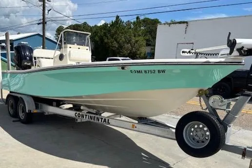 Slide: The Image of 2014 BlackJack 224 Bay boat on trailer, light blue hull, parked outdoors. - 8