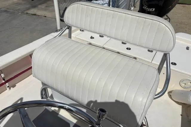 Slide: The Image of 2014 BlackJack 224 Bay boat with white cushioned seating and chrome details. - 9