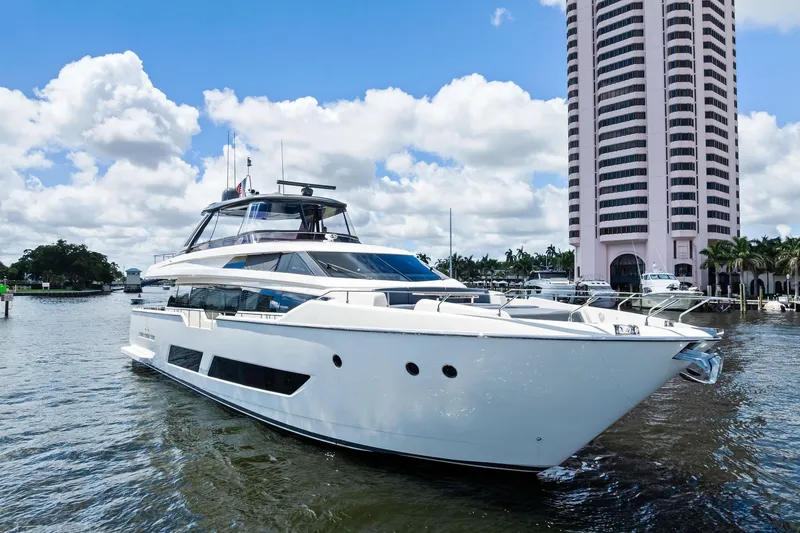 Slide: The Image of 2018 Ferretti Yachts 850 Motoryacht docked near a tall building, under a blue sky. - 1