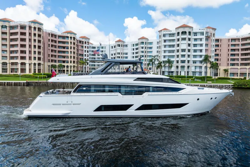 Slide: The Image of 2018 Ferretti Yachts 850 Motoryacht cruising near waterfront buildings. - 5
