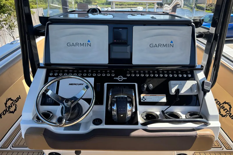 Slide: The Image of 2019 Fountain 38 CC LS boat with triple Mercury outboard engines in a driveway. - 14