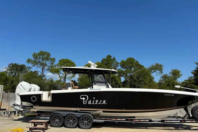 Slide: The Image of 2019 Fountain 38 CC LS boat under clear blue sky, showcasing sleek design and branding. - 17