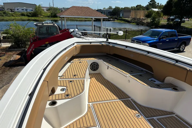 Slide: The Image of 2019 Fountain 38 CC LS boat with tan seating, docked outdoors under clear blue sky. - 9