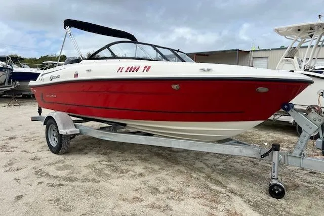 The Image of 2022 Bayliner VR4 Bowrider OB in red on a trailer, parked outdoors. - 0