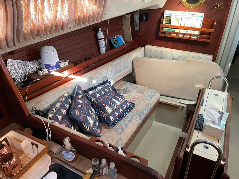 Slide: The Image of Cozy interior of 1982 O'Day 34 sailboat with nautical-themed cushions and wooden accents. - 11