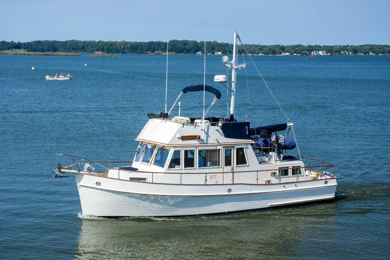 The Image of 1990 Grand Banks 36 Classic yacht cruising on calm blue waters. - 0