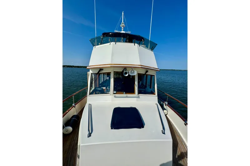 Slide: The Image of 1990 Grand Banks 36 Classic cabin with wooden interior and cozy bed. - 14