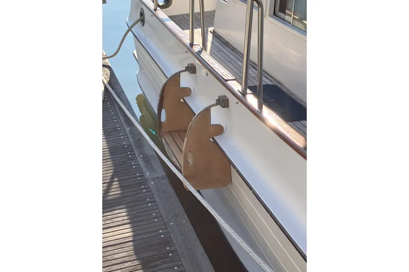 Slide: The Image of 1990 Grand Banks 36 Classic boat deck with wooden railings and water view. - 20