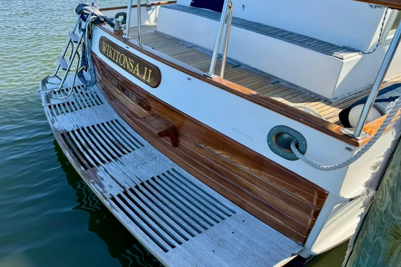 Slide: The Image of 1990 Grand Banks 36 Classic yacht stern with wooden deck and metal railings. - 26