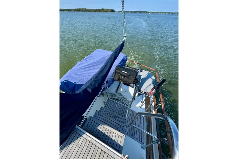 Slide: The Image of 1990 Grand Banks 36 Classic yacht with covered dinghy on deck, docked under clear blue sky. - 29