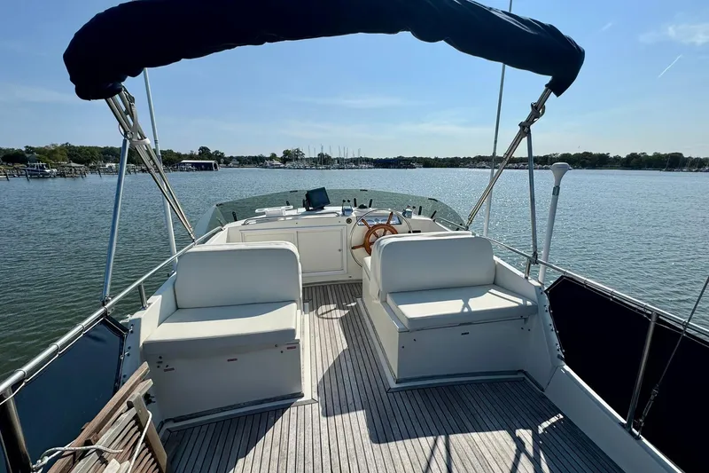 Slide: The Image of 1990 Grand Banks 36 Classic boat on calm water with distant shoreline. - 32