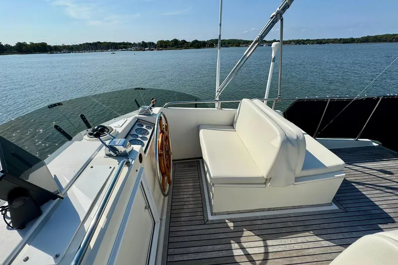 Slide: The Image of 1990 Grand Banks 36 Classic yacht on calm water, featuring a covered upper deck. - 33