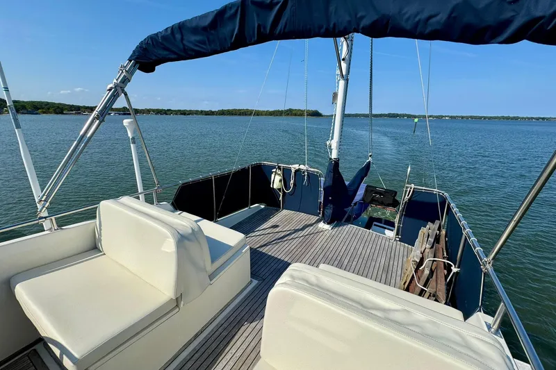 Slide: The Image of 1990 Grand Banks 36 Classic yacht on calm water, featuring a covered deck and scenic view. - 34
