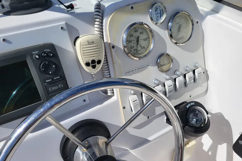 Slide: The Image of 2004 Pro-Line 20 DC boat dashboard with steering wheel, gauges, and navigation equipment. - 13