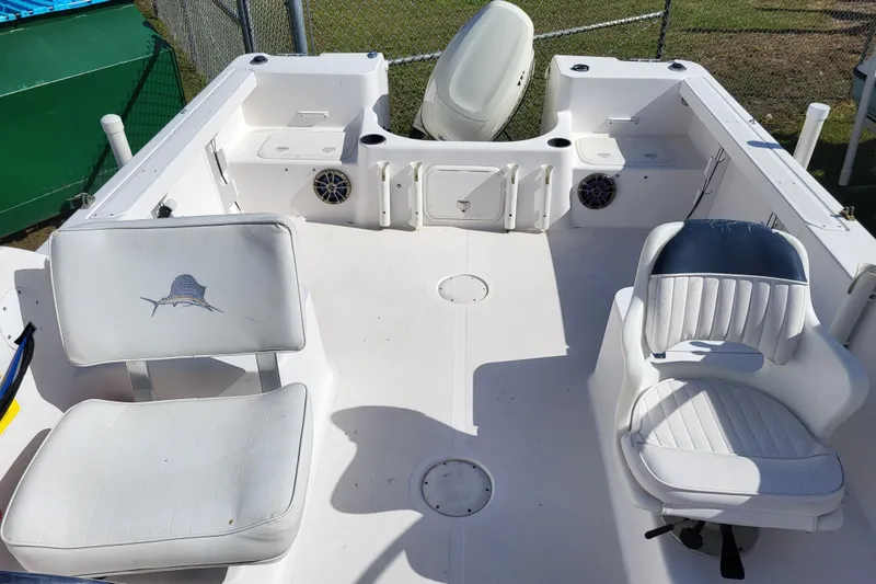 Slide: The Image of 2004 Pro-Line 20 DC boat interior with white seating and fishing rod holders. - 14