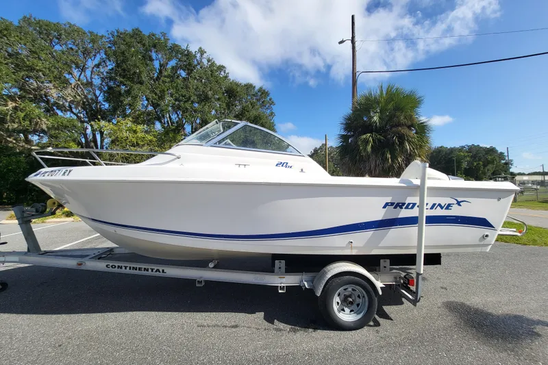 Slide: The Image of 2004 Pro-Line 20 DC boat on trailer, parked outdoors under clear sky. - 3
