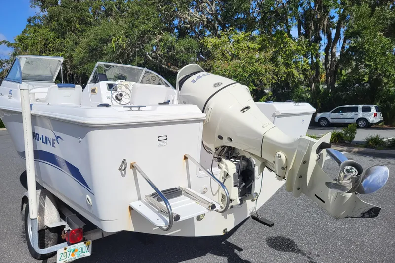 Slide: The Image of 2004 Pro-Line 20 DC boat with outboard motor on a trailer, parked outdoors. - 5
