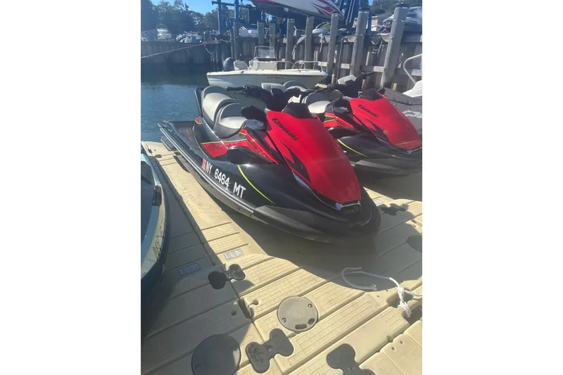 Slide: The Image of 2023 Kawasaki Jetski STX 160 in red, docked at a marina. - 0