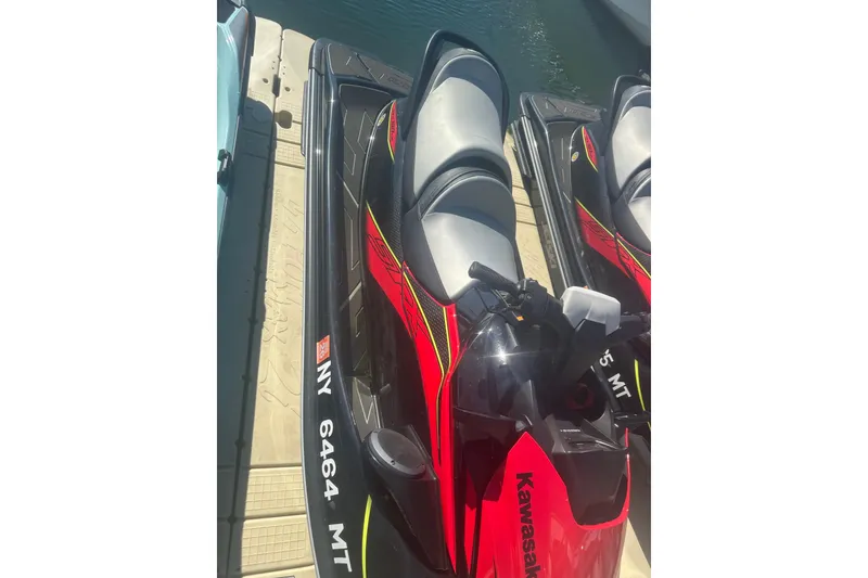 Slide: The Image of 2023 Kawasaki Jetski STX 160 docked, featuring sleek red and black design. - 2