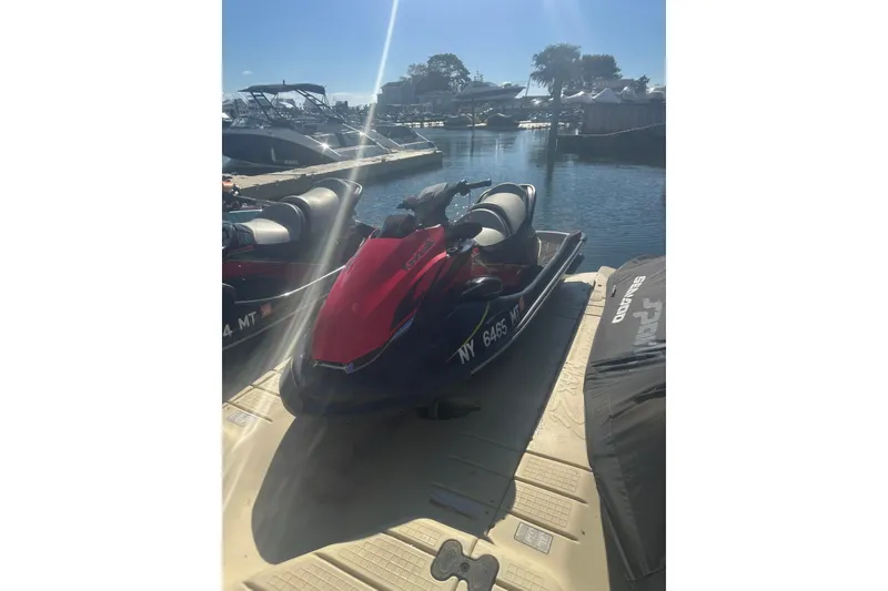 Slide: The Image of 2023 Kawasaki Jetski STX 160 docked at a marina under clear skies. - 9