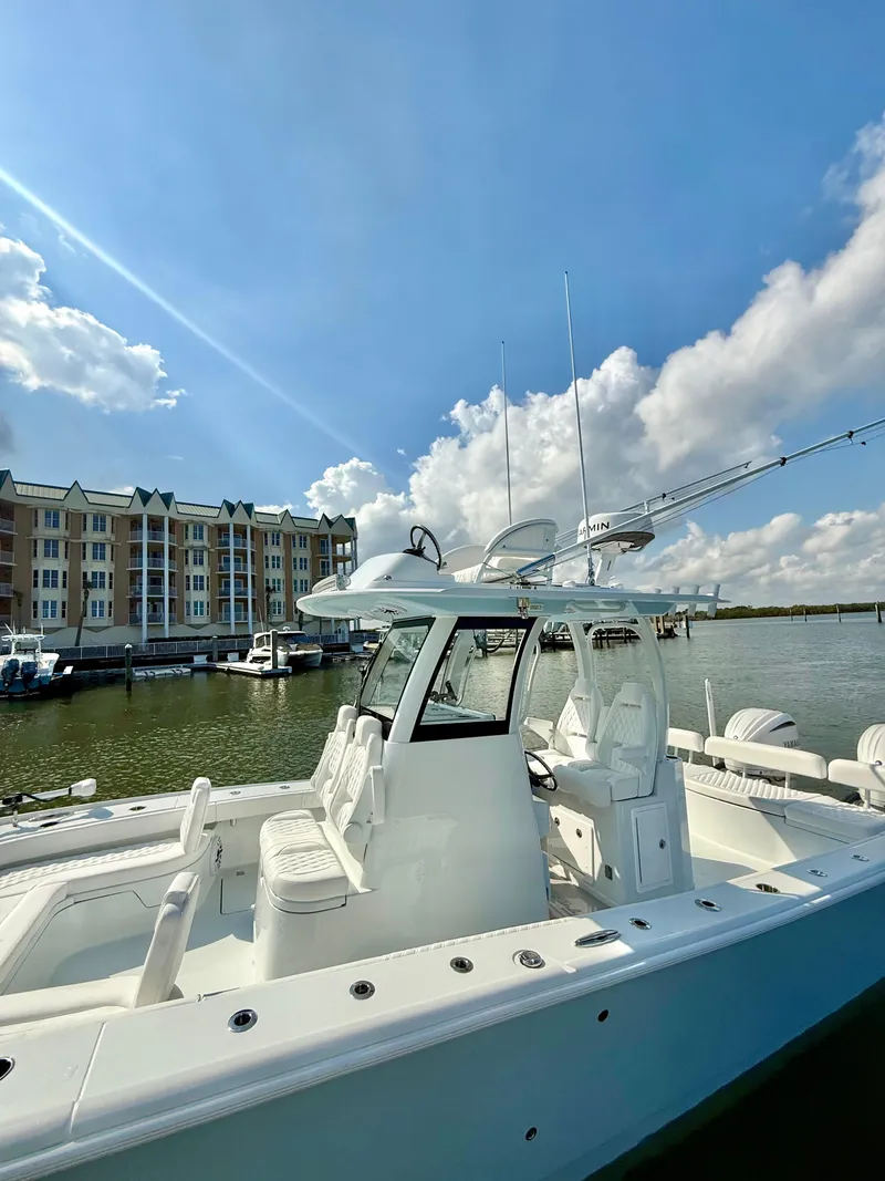 Slide: The Image of 2025 Freeman 28 boat docked by waterfront buildings under a clear blue sky. - 15