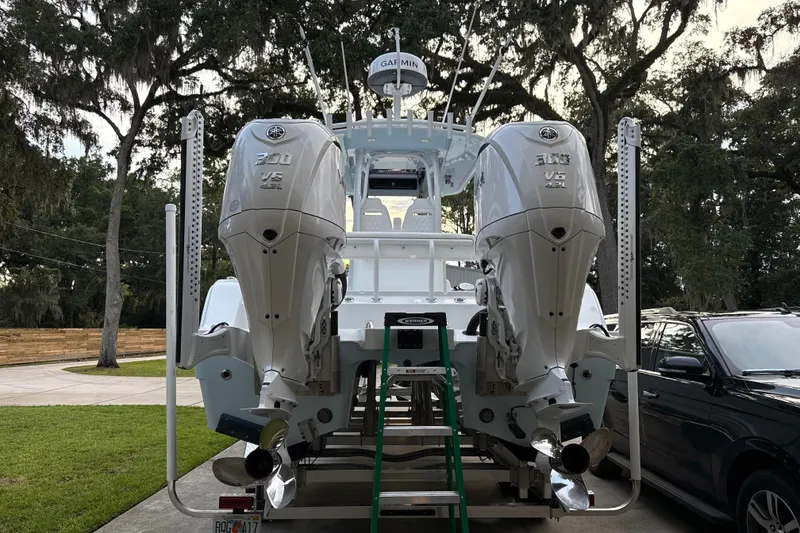 Slide: The Image of 2025 Freeman 28 boat with dual Yamaha V6 300 engines, parked outdoors. - 25