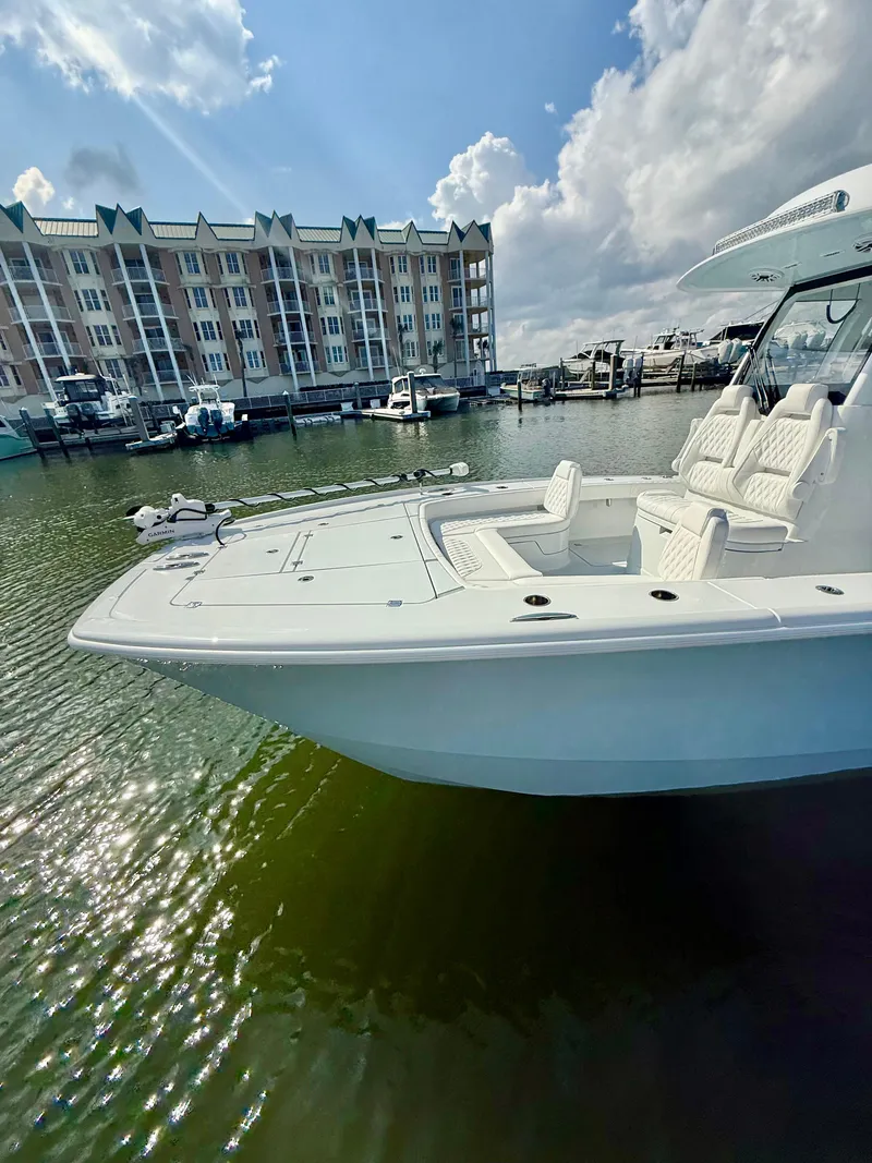 Slide: The Image of 2025 Freeman 28 boat docked in marina, with waterfront buildings and cloudy sky. - 4